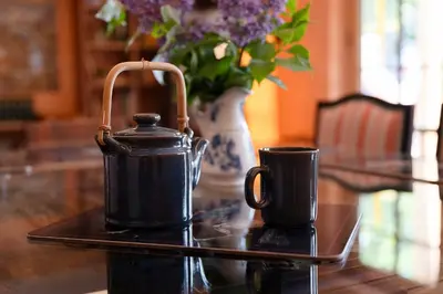 a table with two coffee cups and a vase with flowers at Haus Himmelfahrt in Soprabolzano