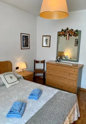 a bedroom with a bed with two blue pillows on it at Appartamento Casa Serena in Siror