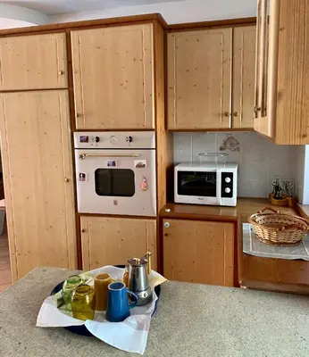 a kitchen with wooden cabinets and a counter top at Appartamento Casa Serena in Siror
