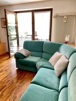 a living room with a green couch in a room at Appartamento Casa Serena in Siror