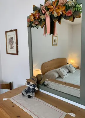 a bedroom with a bed with a wreath on the wall at Appartamento Casa Serena in Siror