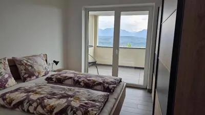 a bedroom with a bed and a view of a balcony at Haus Bonell in Pianizza di Sopra