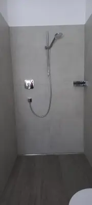 a bathroom with a shower with a hose on the wall at Haus Bonell in Pianizza di Sopra