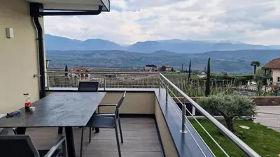 a balcony with a table and chairs and mountains at Haus Bonell in Pianizza di Sopra