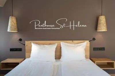 a bedroom with a bed with two lights above it at Traumhaftes Panorama und Wohlfühl-Wellness im Penthouse St. Helena in Partschins in Parcines