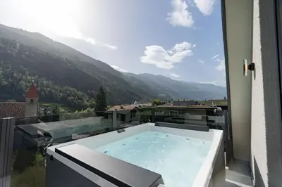 a jacuzzi tub filled with water in a room at Traumhaftes Panorama und Wohlfühl-Wellness im Penthouse St. Helena in Partschins in Parcines