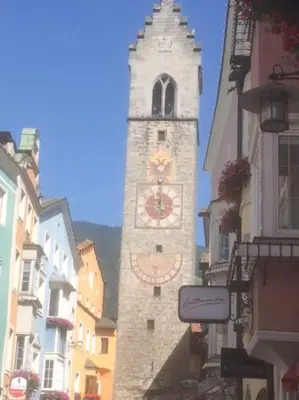 a tall clock tower in the middle of a street at BIS Vipiteno in Vipiteno