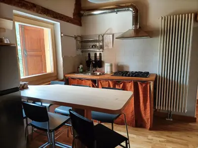a kitchen with a table and chairs and a stove at Resort CuraLibera in Ronzone