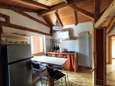 a kitchen with a table and a refrigerator at Resort CuraLibera in Ronzone