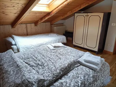 a attic room with two beds and a refrigerator at Resort CuraLibera in Ronzone
