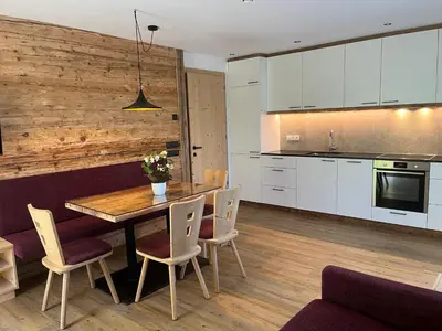 a kitchen and dining room with a wooden table and chairs at Apartment Pichlerhof in San Lorenzo di Sebato