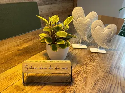 a table with a vase with a plant and a sign at Apartment Pichlerhof in San Lorenzo di Sebato