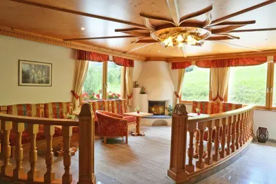 a living room with a staircase and a ceiling fan at Apartment Pichlerhof in San Lorenzo di Sebato
