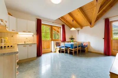 a kitchen and dining room with a table and chairs at Garni Bergland in Racines