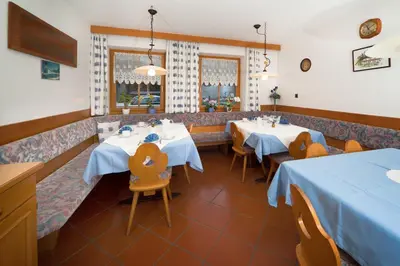 a restaurant with two tables and chairs with blue table cloth at Garni Bergland in Racines