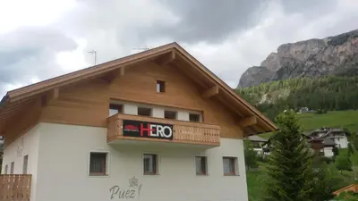 a building with a sign that says hoo on it at Appartamento Puez in Selva di Val Gardena