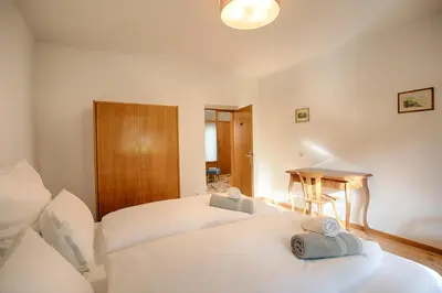 a bedroom with two beds and a table in it at Apartment Hofgarten - Alpstay in Naturno