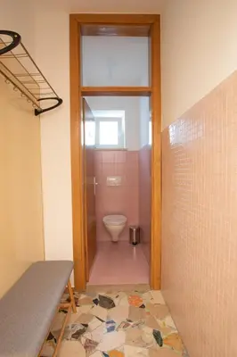 a bathroom with a toilet and a glass door at Apartment Hofgarten - Alpstay in Naturno