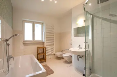a bathroom with a tub and a toilet and a sink at Apartment Hofgarten - Alpstay in Naturno