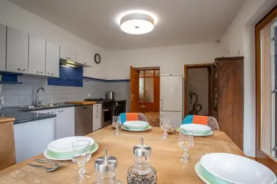 a kitchen with a wooden table with plates and glasses on it at Apartment Hofgarten - Alpstay in Naturno