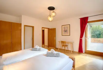a bedroom with two beds and a table at Apartment Hofgarten - Alpstay in Naturno