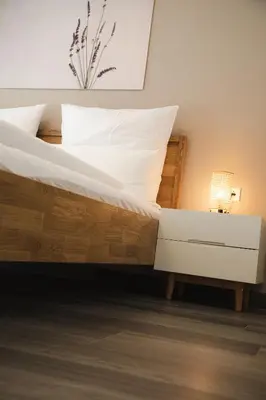 a bedroom with a bed and a nightstand with a white drawer at Apartment Lavendel - Alpstay in Naturno