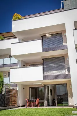 a white building with a table and chairs at Apartment Lavendel - Alpstay in Naturno