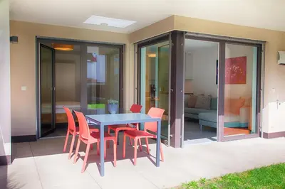 a patio with a blue table and red chairs at Apartment Lavendel - Alpstay in Naturno
