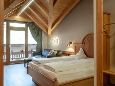 a bedroom with two beds and a couch at Hotel Bacherhof in Maranza