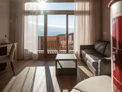 a living room with a couch and a large window at Hotel Bacherhof in Maranza