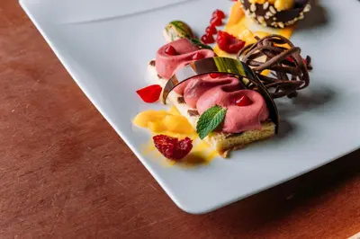 a white plate with a dessert on a table at Hotel Bacherhof in Maranza
