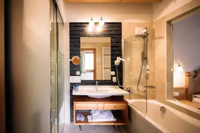 a bathroom with a sink and a tub and a mirror at Hotel Bacherhof in Maranza