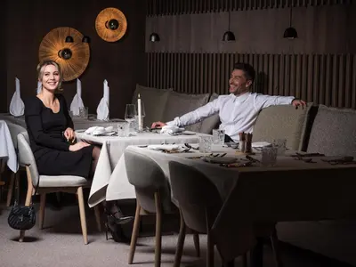 a man and woman sitting at a table in a restaurant at Hotel Bacherhof in Maranza