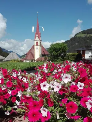 a bunch of flowers in front of a church at Apartment Pössnecker in Selva di Val Gardena