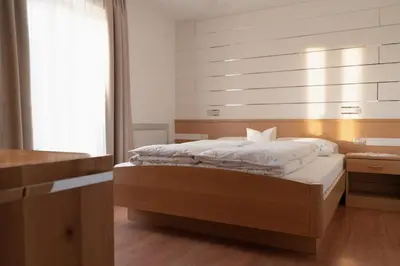 a bedroom with a bed in a room with a window at Apartment Pössnecker in Selva di Val Gardena