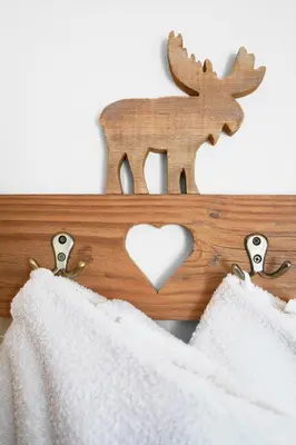 a wooden sign with a deer and a heart at Apartment Pössnecker in Selva di Val Gardena