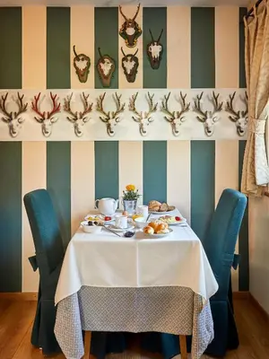 a table with a white table cloth and blue chairs at Garni Karin in Corvara in Badia