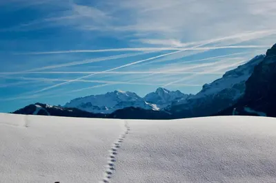 a track in the snow with mountains in the background at Garni Karin in Corvara in Badia