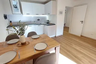a kitchen with a wooden table with chairs and a dining room at Renovated flat close to the centre in Merano