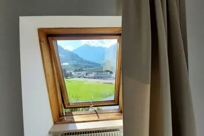 a window with a view of a golf course at Renovated flat close to the centre in Merano