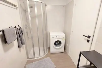 a bathroom with a washing machine and a washer at Renovated flat close to the centre in Merano