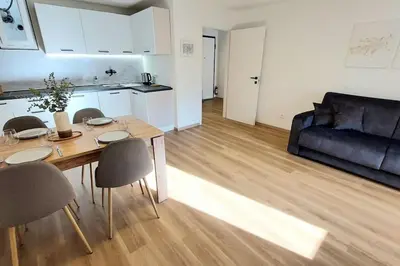 a living room with a table and chairs and a couch at Renovated flat close to the centre in Merano