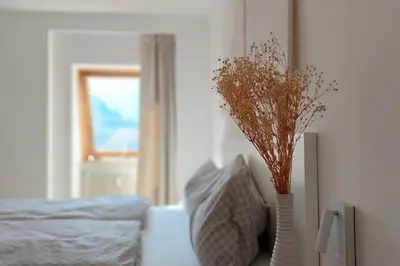 a bedroom with two vases with flowers in it at Renovated flat close to the centre in Merano