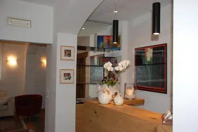 a living room with a table with flowers in vases at Aparthotel Pichler in Colle Isarco