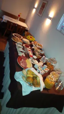 a long table with many plates of food on it at Aparthotel Pichler in Colle Isarco