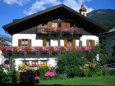 a building with flowers on the side of it at Aparthotel Pichler in Colle Isarco
