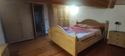 a bedroom with a wooden bed and a wooden floor at A&J House in Canale San Bovo