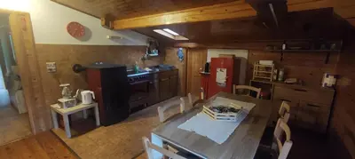 a kitchen with a dining table and a red refrigerator at A&J House in Canale San Bovo