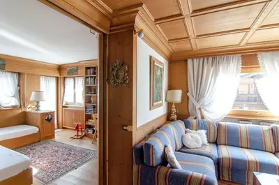 a living room with a couch and a window at Splendido appartamento a due passi dal centro con terrazza e garage in Cortina dʼAmpezzo