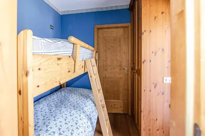 a bunk bed with a ladder in a room at Splendido appartamento a due passi dal centro con terrazza e garage in Cortina dʼAmpezzo